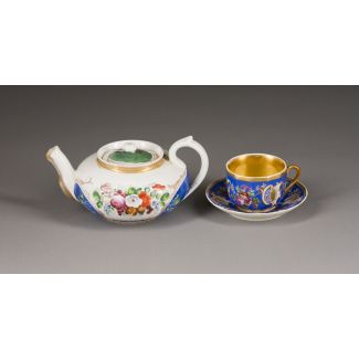 A PORCELAIN CUP UND A SAUCER WITH A TEAPOT 